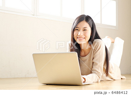 ノートパソコンを使う女性（フローリング・寝る） 6486412