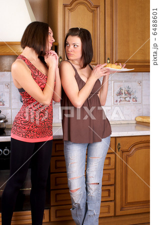 Two woman with croissant in the kitchen Two woman with croissant in the kitchen 6488601