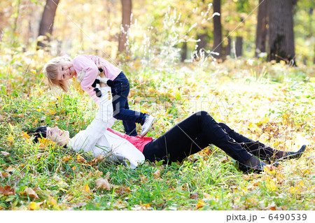 beautiful young mother and her daughter lying on the autumn leav 6490539