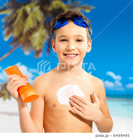 boy applying sun block cream on the tanned body boy applying sun block cream on the tanned body 6499495