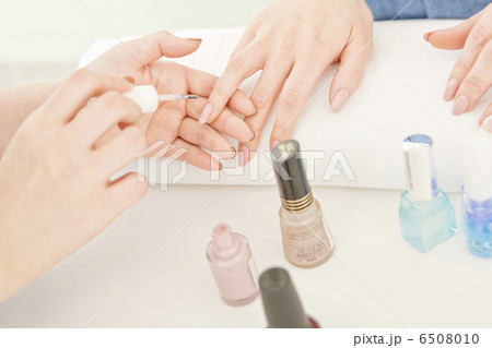 ネイルサロンでマニキュアを塗っている女性の手元の写真素材