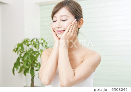 両手で頬を触っている女性 6508042