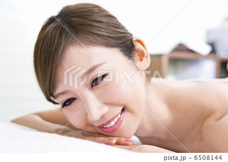 うつ伏せになっている笑顔の女性 6508144