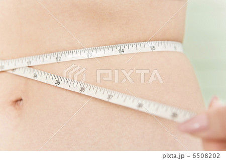 メジャーでウエストサイズを測っている女性 6508202