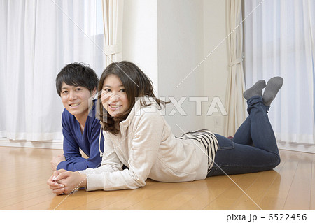 新居のリビングルームに寝ころぶ若いカップル 新居のリビングルームに寝ころぶ若いカップル 6522456