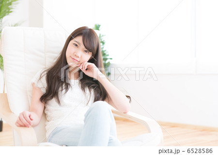 部屋でリラックスする若い女性 6528586