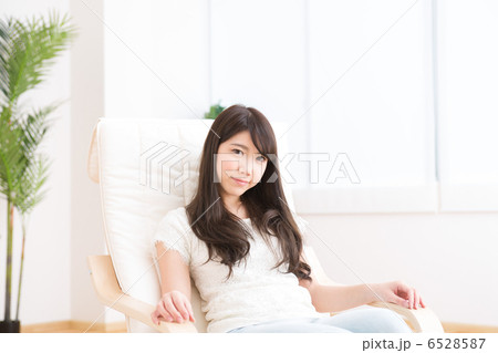 部屋でリラックスする若い女性 6528587