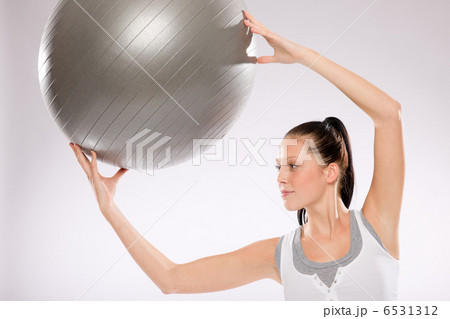Young woman doing exercises with fitness ball Young woman doing exercises with fitness ball 6531312