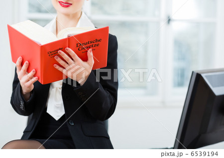Lawyer in office reading law book 6539194