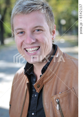 Handsome young man smiling outdoors 6542137