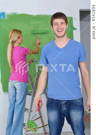 happy couple paint wall at new home 6542894