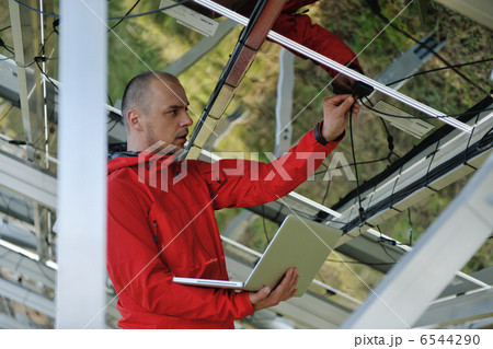 engineer using laptop at solar panels plant field 6544290