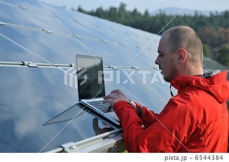 engineer using laptop at solar panels plant field engineer using laptop at solar panels plant field 6544384