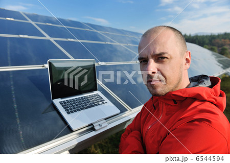 engineer using laptop at solar panels plant field engineer using laptop at solar panels plant field 6544594