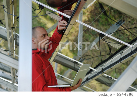 engineer using laptop at solar panels plant field engineer using laptop at solar panels plant field 6544596
