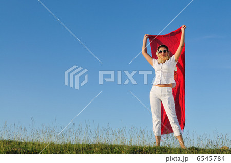 beautiful woman with red scarf on meadow 6545784