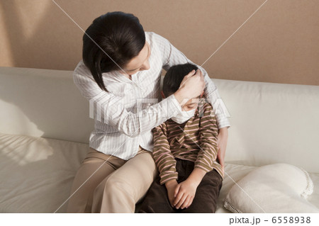 マスクを着けた男の子を抱く母親 6558938