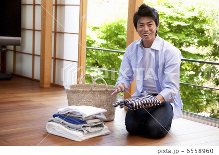 たたんだ衣類と笑顔の男性 6558960