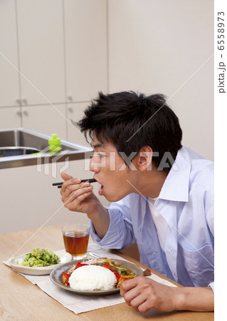 箸で食事をする男性 6558973