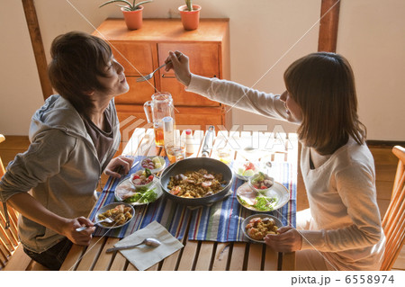 若い男性に料理を食べさせる若い女性 6558974