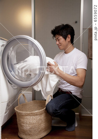 洗濯機から洗濯物を取り出す男性 6559072