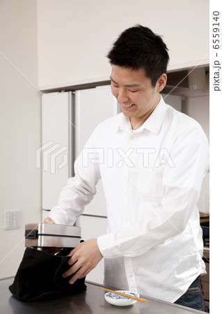 弁当をランチバックに入れる男性 6559140