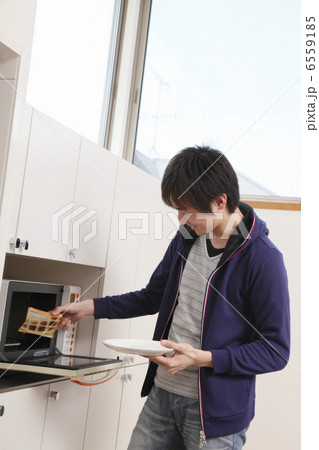 レンジからトーストを取り出す男性 6559185