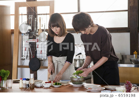 キッチンで一緒に料理をする若いカップル 6559198