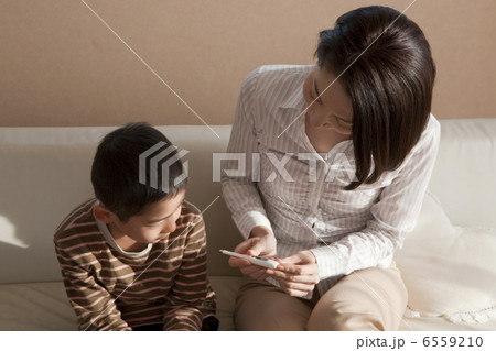 体温計を一緒に眺める母親と男の子 体温計を一緒に眺める母親と男の子 6559210