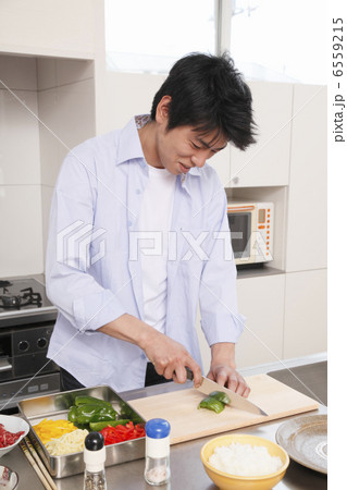 包丁でピーマンを切る男性 6559215