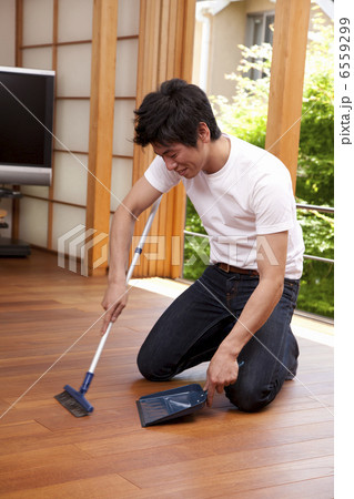 チリトリで床のゴミを取る男性 6559299