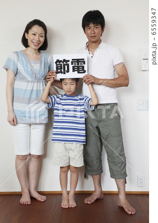 節電のボードを持つ男の子と両親 6559347