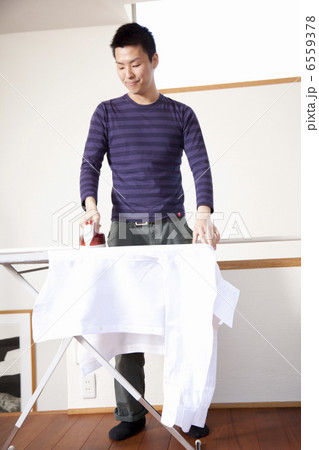 シャツにアイロンをかける男性 6559378