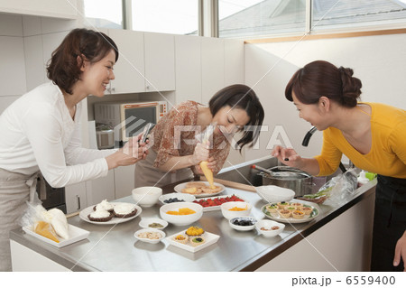 キッチンで菓子作りをする三人の女性 キッチンで菓子作りをする三人の女性 6559400