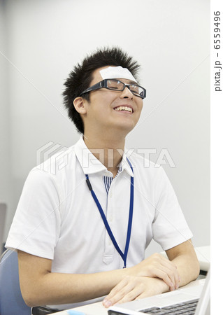 冷却ジェルシートを貼って目を閉じる男性 6559496