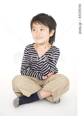 胡座をかいて頬杖をつく男の子の写真素材