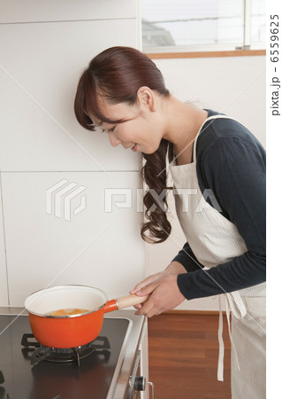 鍋を火にかける女性 鍋を火にかける女性 6559625
