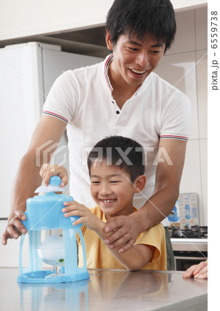 父親と一緒にかき氷を作る男の子 6559738