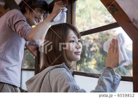 窓ガラスを一緒に拭く若いカップル 窓ガラスを一緒に拭く若いカップル 6559812