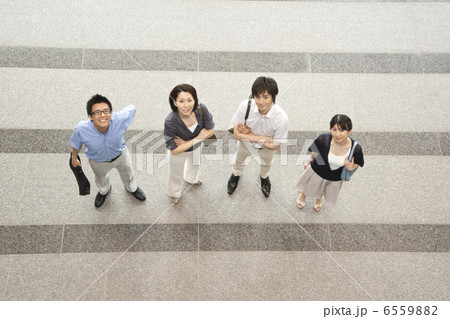 腕を組んで見上げるクールビズの男女４人 6559882
