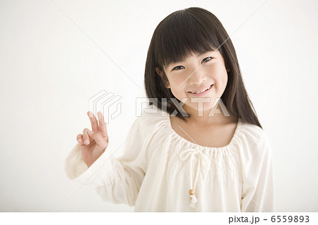 笑顔でVサインをする女の子 6559893