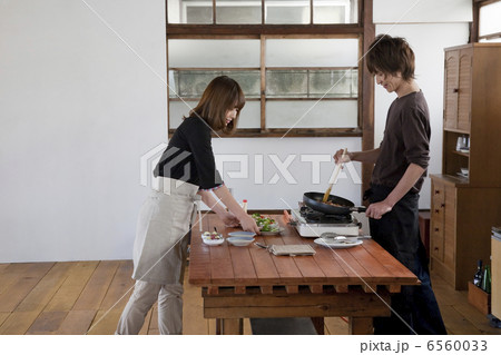 キッチンで一緒に料理をする若いカップル キッチンで一緒に料理をする若いカップル 6560033