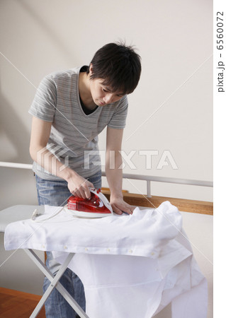 シャツのアイロンがけをする男性 6560072