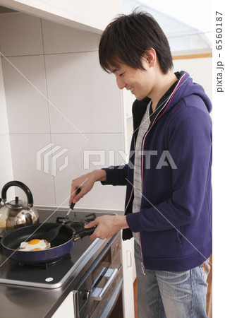 目玉焼きを作る男性 6560187