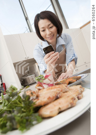 スマートフォンで料理を撮影する女性 6560264