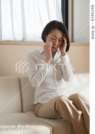 こめかみを押さえる女性 6560266
