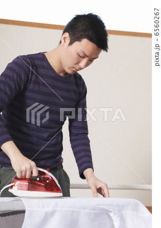 シャツのアイロンがけをする男性 6560267