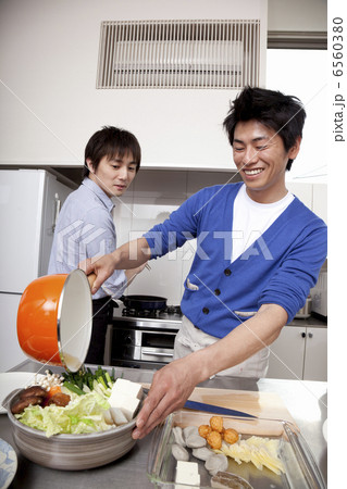鍋にだし汁を入れる男性と振り向く男性 6560380