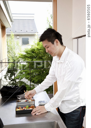 弁当箱におかずを詰める男性 6560505
