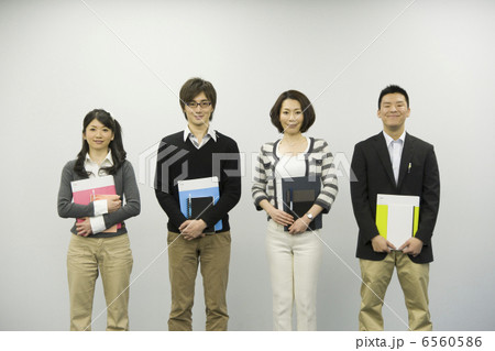 ファイルとノートを持ち並んで立つ男女４人 6560586